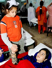 US-born nine-year-old Manjot Singh comforts an earthquake injured Kashmiri woman during the visit of a Sikh delegation from US to Agha Khan medical camp in Islamabad on Friday