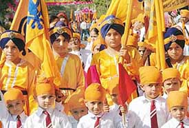 Young devotees take part in a nagar kirtan in connection with Guru Nanak Dev's birth anniversary celebrations in Chandigarh