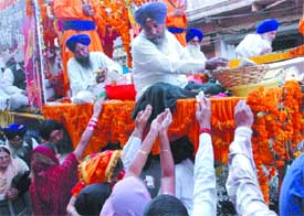 Devotees seek parshad during a procession taken out in connection with the birth anniversary of Guru Nanak Dev in Jalandhar on Saturday