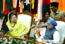 Bangladesh Prime Minister Khaleda Zia gets her glasses from an aide as Dr Manmohan Singh looks on during the closing session of the 13th SAARC Summit in Dhaka on Sunday