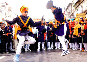 Sikh youth showing their skill with swords during a procession from Gurdwara Sheesh Gunj at Chandni Chowk to mark the birth anniversary celebrations of Guru Nanakdev on Monday