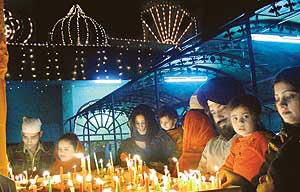 Devotees light candles at the Sector 20 gurdwara during Gurpurb celebrations in Chandigarh on Tuesday.