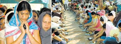 A devotee offers prayers before Guru Granth Sahib on the occasion of the birth anniversary of Guru Nanak Dev at Gurdwara Sri Guru Singh Sabha, Model Town, in Jalandhar on Tuesday. (Right) Devotees partake of langar at the gurdwara