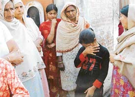Neighbours console 11-yr-old Ripanjit Kaur whose father shot her mother in Bajra village, Ludhiana, on Tuesday