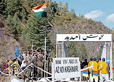 Indian porters (right) walk as Indian Kashmiri people watch relatives during the opening of the fifth crossing point on the LoC on Wednesday. 