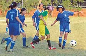 A St. Xaviers player tries to dodge St Stephens players in the seventh Chandigarh State Womens Football Championship in Chandigarh on Thursday.