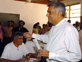 Sri Lanka 's main opposition leader and presidential candidate Ranil Wickremsinghe stands in queue to cast vote at a polling booth in Colombo 