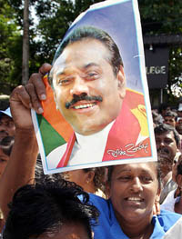 A woman holds a poster of President-elect Mahinda Rajapakse on a street in Colombo on Friday.
