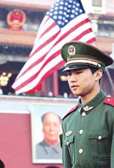 Chinese paramilitary policeman patrols Tiananmen Square with the US flag flying beside the portrait of former Chinese leader Mao Zedong in Beijing on Saturday.