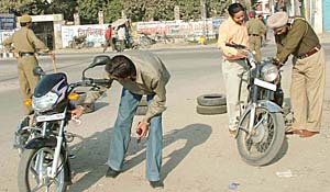 Police officials check motorcycles at a naka outside the District Administrative Complex in Jalandhar on Saturday.