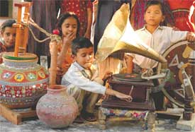 Children of today have a feel of the yesteryears as one winds an old gramophone while another holds on to a charkha at Khuda Lahora village which is being developed as a rural tourism destination