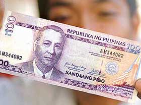 A street vendor shows a 100 peso Philippine note with President Gloria Arroyos last name mispelt 