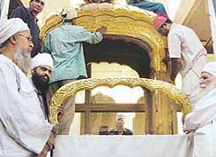 Baba Jagtar Singh of Tarn Taran watches artisans giving final touches to the gold palanquin in Amritsar on Monday. 