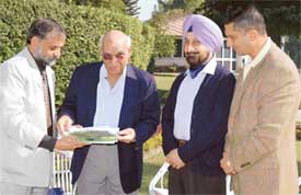 T.P.S Sandhu presents his book, Songs of Season, to Yash Chopra, in Phillaur on Saturday. Director of Punjab Police Academy, Mr R.S Gill and senior advocate, Mr Harpreet Sandhu, are also seen in the picture