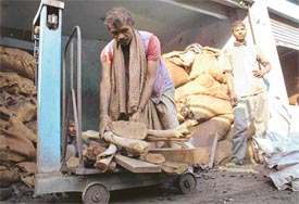 A man weighs firewood at a shop