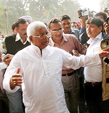 Mediapersons surround RJD chief Lalu Prasad in Patna on Tuesday after his party was defeated in the Bihar Assembly poll.
