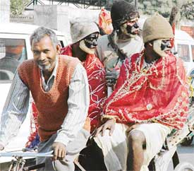 A group of behrupiyas riding a rickshaw look intently at something while the rickshaw-puller is amused at the attention he is getting because of them