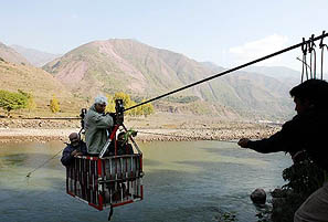 Earthquake survivors cross the Jhelum