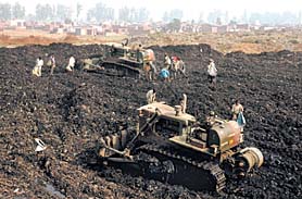 Two Army bulldozers clean up the garbage dump at Wariana village in Jalandhar on Thursday.