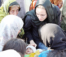 Actress and United Nations High Commissioner for Refugees ( UNHCR) Goodwill Ambassador Angelina Jolie ( right ) touches a two-month-old earthquake survivor at a UNHCR refugee camp in Gari Habibullah in occupied Kashmir on Friday. 