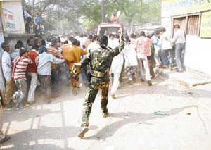 Policemen chase family members of prisoners demonstrating in front of the Jehanabad district jail