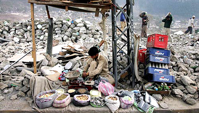An earthquake survivor opens a shop in the rubble in the devastated town of Balakot in Pakistan on Saturday