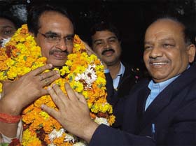 Newly nominated Chief Minister of Madhya Pradesh Shivraj Singh Chauhan being garlanded by Delhi BJP president Dr Harsh Vardhan, at his residence in the Capital