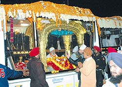 The golden palki carrying Guru Granth Sahib in a specially-designed bus on its way to Pakistan via the Wagah border stops over in Jalandhar on Monday. 