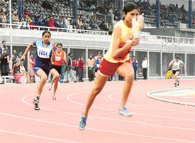 Girls in action in a relay race during the 51st Punjab State Schools Inter-District Athletics Meet in Ludhiana on Monday