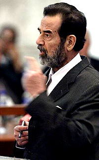 Former Iraqi President Saddam Hussein speaks to Presiding Judge Rizgar Mohammed Amin in Baghdad on Monday