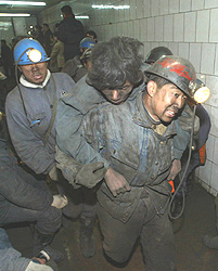 A rescuer carries a miner trapped in a coal mine blast in Qitaihe, in northeast China's Heilongjiang province, on Monday