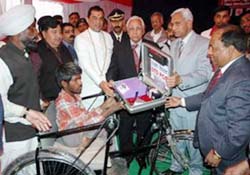 The Haryana Governor, Dr A.R. Kidwai, distributes tricycles and allots std pcos to physically challenged persons at a function in Kurukshetra on Tuesday. 