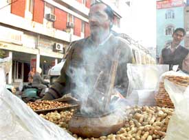 Smoke emanates from a pot heating peanuts at a rehri in Ludhiana on Tuesday