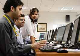 Stock dealers work at a brokerage during hectic trading as Sensex touched a record high of 9,033 during intra-day trading in Mumbai on Friday.  Strong buying by overseas funds has made the benchmark index bullish with net investments of $8.7 billion in 2005.