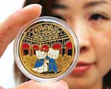 Japanese money commodity trader Taisei Coins employee displays a gold coin, designed with popular character of Hello Kitty, minted by Monnaire de Paris of France, at the companys showroom in Tokyo on Friday. The one-ounce gold coin is priced at 1,68,000 yen ($1,400) each. 