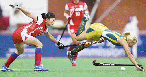 Australias Nikki Hudson is brought down by Koreas Cho Hye Sook during a match