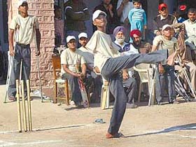 Sunil Kumar, who lost his arms, hits a six with his leg during a cricket match of physically challenged children at Saket in Chandi Mandir