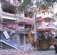 An MCD bulldozer razing an unauthorised construction at Balraj Khanna Marg, Patel Nagar, in the Capital on Saturday.