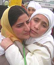 A pilgrim hugs her daughter as they leave for Haj pilgrimage in Srinagar on Saturday.