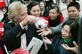 The chairman of Virgin Atlantic Airlines, Sir Richard Branson, hands out teddy bears to a large crowd outside a departmental store in Shanghai