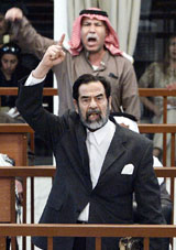 Former Iraqi President Saddam Hussein and his former intelligence chief Barzan Ibrahim al-Tikriti berate the court during their trial in Baghdad 