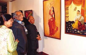 Haryana Chief Minister Bhupinder Singh Hooda and former Indian ambassador to UK L.M. Singhvi being taken around an exhibition of paintings The Last Song by the artist Vijaya Goel at India International Centre in the Capital