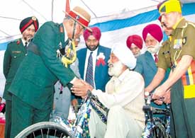 Lt Gen Mandhata Singh, GOC, Vajra Corps, hands over a tricycle to a physically-challenged ex-serviceman in Jalandhar on Wednesday