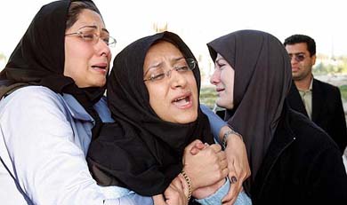 Family members of a journalist, who was killed during a plane crash, mourn as they arrive at the coroner's office in Teheran on Wednesday. At least 116 persons were killed when a military plane hit an apartment block and burst into flames. Among the dead were 68 journalists and media technicians, en route to cover military exercises in the Gulf.