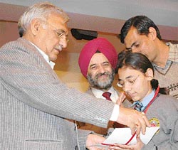 Haryana Chief Minister Bhupinder Singh Hooda gives away award to a meritorious student at a state level function at Ambala Cantt on Friday