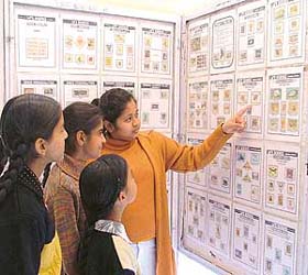 Children watch postal stamps at an exhibition held at Lodhi Club in Ludhiana