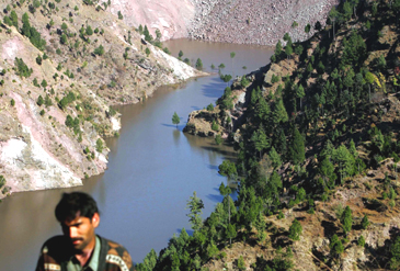 An earthquake survivor stands in front of a lake created by a landslide in the village of Kalrahi, 55 km southeast of Muzaffarabad in Pakistan-administered Kashmir, on Saturday. 