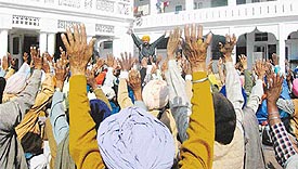 Residents of UT villages raise their hands in support of their demands during a rally organised at Shahpur gurdwara, Sector 38, Chandigarh, on Sunday.