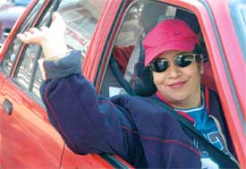 A smile and a wave of the hand as this woman on the wheel sets out for a fun drive from Sector 8, Madhya Marg