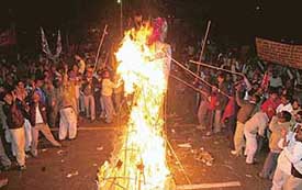 Activists of the All-India Confederation of SC/ST Organisations burn an effigy of Indian industrialists to demand reservation in private sector units at Jantar Mantar in New Delhi on Sunday
